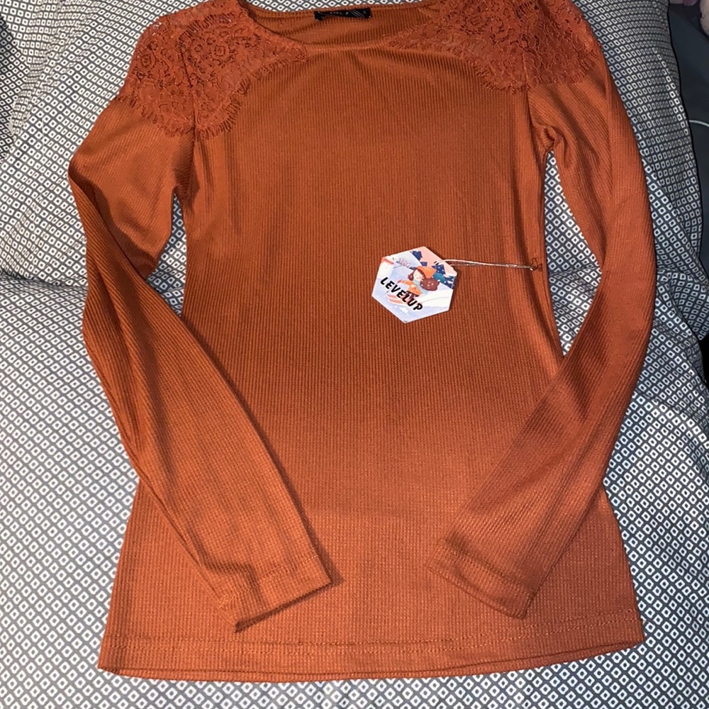 A long sleeve red/orange shirt, size small it’s brand new the tag is till on it